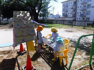 写真：みんなで作った屋根の下でままごとを楽しむ年中女児と年少児