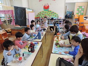 写真：年長さんはみんなのお顔が見えるように食べています