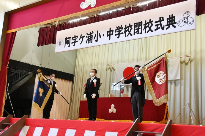 写真：阿字ヶ浦小学校長から学校旗を受け取る大谷市長