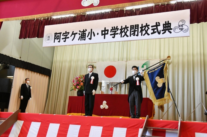 写真：阿字ヶ浦中学校長から学校旗を受け取る大谷市長
