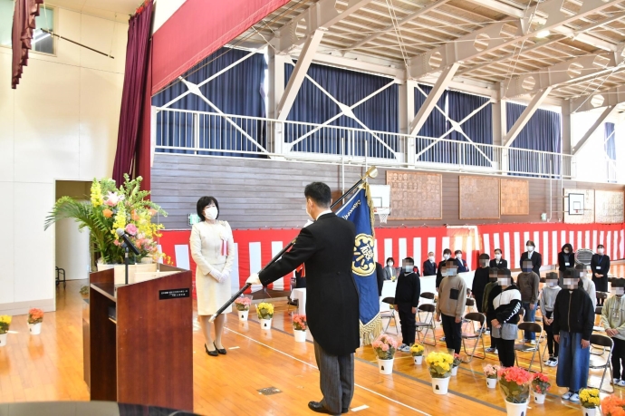 写真：磯崎小学校長から学校旗を受け取った大谷市長