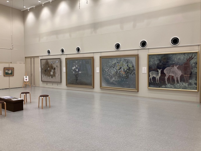 那波多目功一氏の描いた絵画が多数展示されている様子