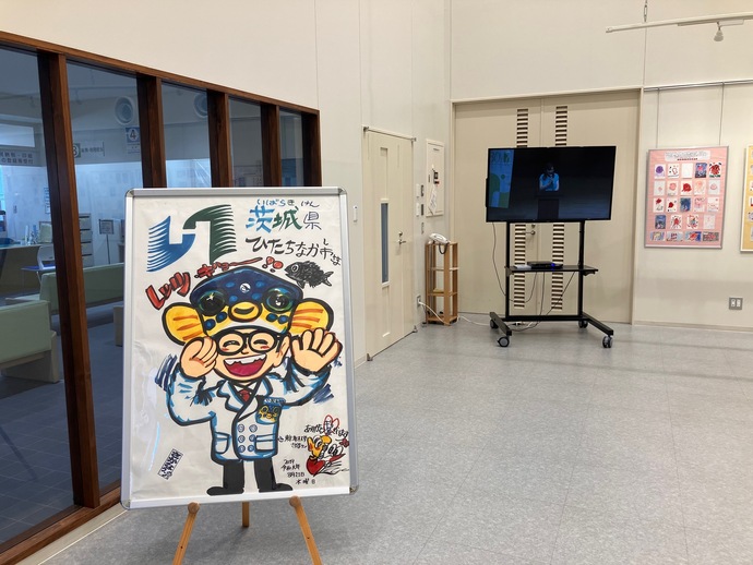 さかなクンがひたちなか市のために描いたイラストの展示や、講演会の動画を放映している様子