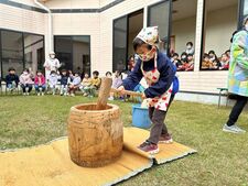 もちつきをするさくら組（5歳児）と見学する子ども達の写真