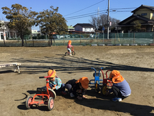 三輪車に砂を載せる子ども達