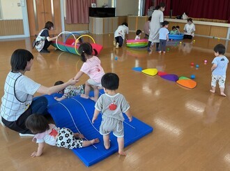 園庭開放に遊びに来てくれたお友達を交えて、ホールで楽しく遊んでいる写真