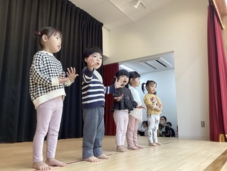 舞台の上で動物になりきって、歌ったり踊ったりする2歳児の写真。