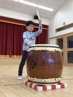 和太鼓をたたく、5歳児男の子の写真。