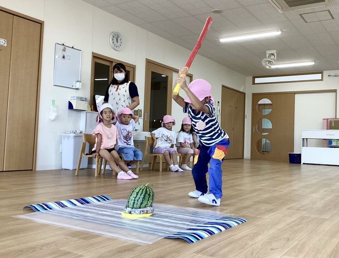 すいか割りをする子どもの写真。