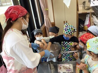 先生と一緒に、月見団子を作る5歳児の画像