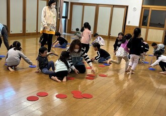 5歳児・くじら組の子ども達がホールでオセロゲームをしている写真