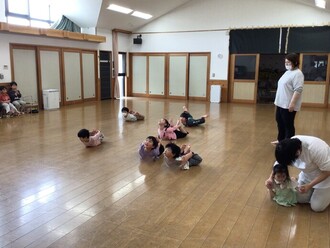 ホールでリズムを行う4歳児の写真