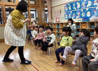 2歳児クラスの子ども達に「やいかがし」を見せている写真