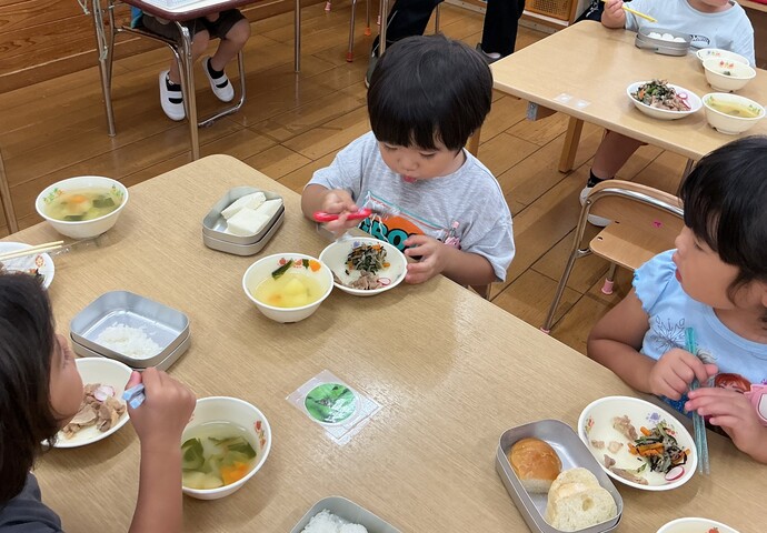 給食で収穫したはつか大根を食べるこども