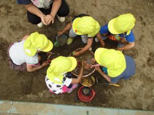 写真：砂場で泥遊びをする子どもたちの写真