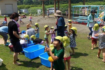 写真：水遊びではしゃぐ子ども達