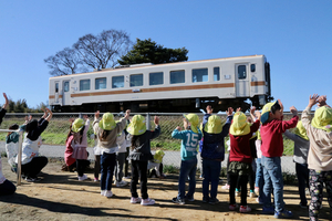 那珂湊第二保育所の園庭からひたちなか海浜鉄道湊線のディーゼル車に手を振る子どもたち