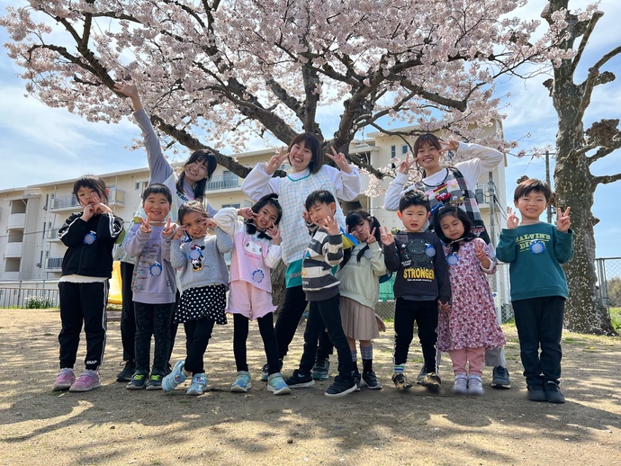 桜の木の下で写真を撮る5歳児