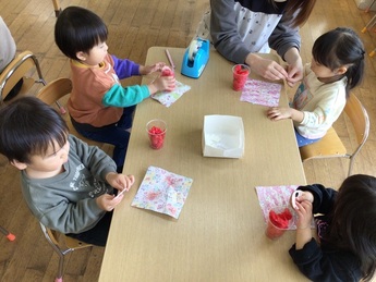 テーブルに座って製作をする子ども