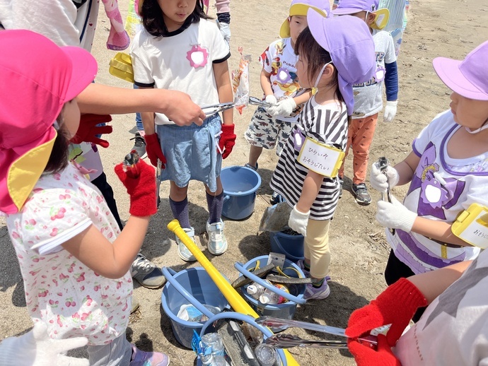 海岸で落ちていたゴミをのぞき込む子ども達。