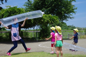 写真：大きなビニール袋をロケットに見立て飛ばすことに驚嘆する子ども達