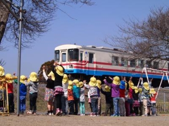 那珂湊第二保育所の園庭から、ひたちなか海浜鉄道に手を振る子どもたちの写真