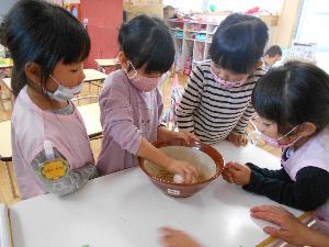 写真：園児がすり鉢の中のお米を見ている