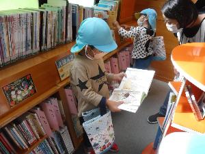 写真：図書館で借りたい本を選んでいる年長男児