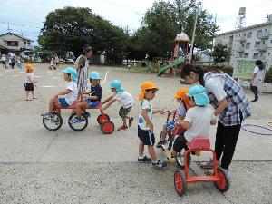 写真：2学期始業式後の園庭で三輪車を楽しむ幼児
