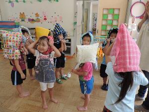写真：防災頭巾を被る練習をする年少児
