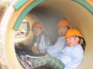 写真：築山のトンネルの中の仲良し年少児