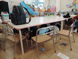 写真：地震の避難訓練で机の下に隠れる年少児の様子