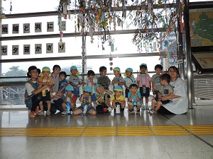 写真：にじ組さんみんなで勝田駅の笹飾りと一緒に記念撮影