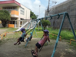 写真：ブランコで気持ちよく立ちこぎをしている年長女児