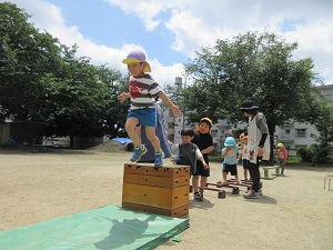 写真：高いところからジャンプをする年長児