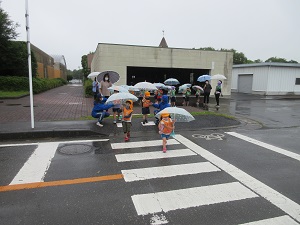 写真：雨の中傘をさして歩行訓練を行っている様子