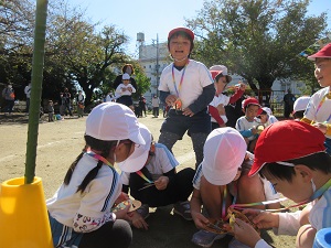 写真：障害物競走後にメダルをもらい喜んでいる幼稚園生