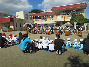 写真：小学生の陣太鼓の演奏を聴いている幼稚園児