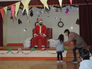 写真:サンタクロースが放蕩に幼稚園に来てくれて動揺している年長女児