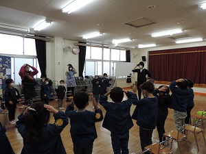 写真：中学校の英語の先生と一緒に体を使って英語の歌を親しむ様子