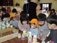 写真:おもちゃ作りに使う木の実や材料を小学生が幼稚園生のために選んでくれている様子