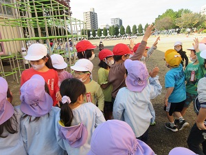 写真：一緒に遊んだ後にまた遊ぶ約束をして別れを惜しむ1年生と年長児