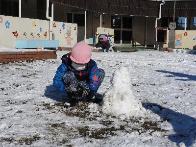 雪が降り雪で遊ぶ子ども達。