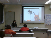 写真：講師が活字と手書きの違いについて説明している様子