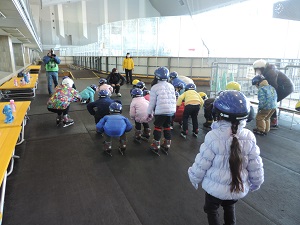 写真:スケート体験教室で年中児と年長児が準備体操をしている