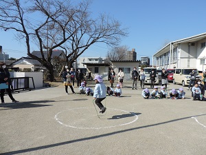 写真：年長児がなわとびのとんだ数を数えてもらっている