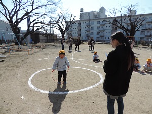 写真：年中児が先生になわとびを数えてもらっている