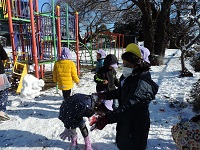 写真:積もった雪で園児が雪合戦を楽しんでいる