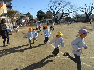 写真:幼稚園生が園庭でマラソンをしている