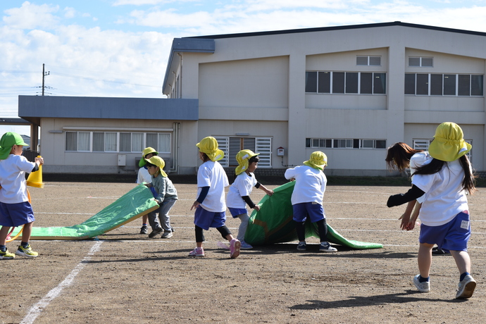 園児が障害物の道具を片付けている。